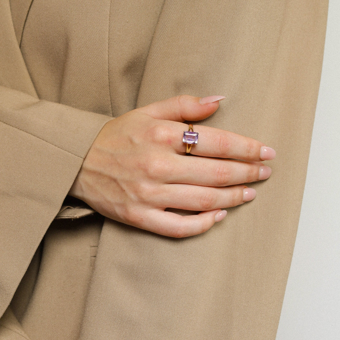 Ring with natural amethyst purple stone on finger on hand