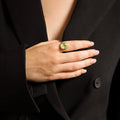 Ring with green olivine on hand on finger