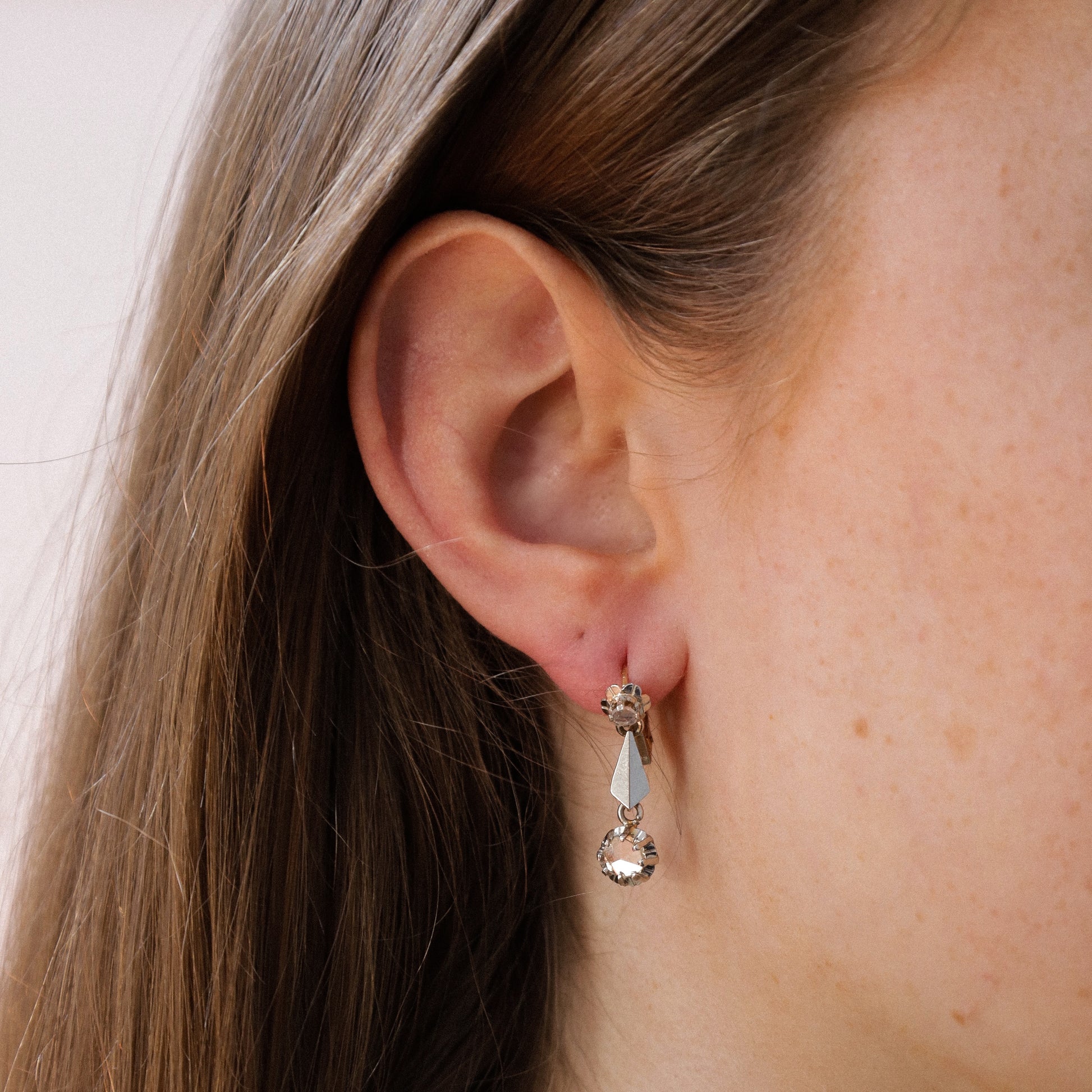 Diamond dangle earrings on ear